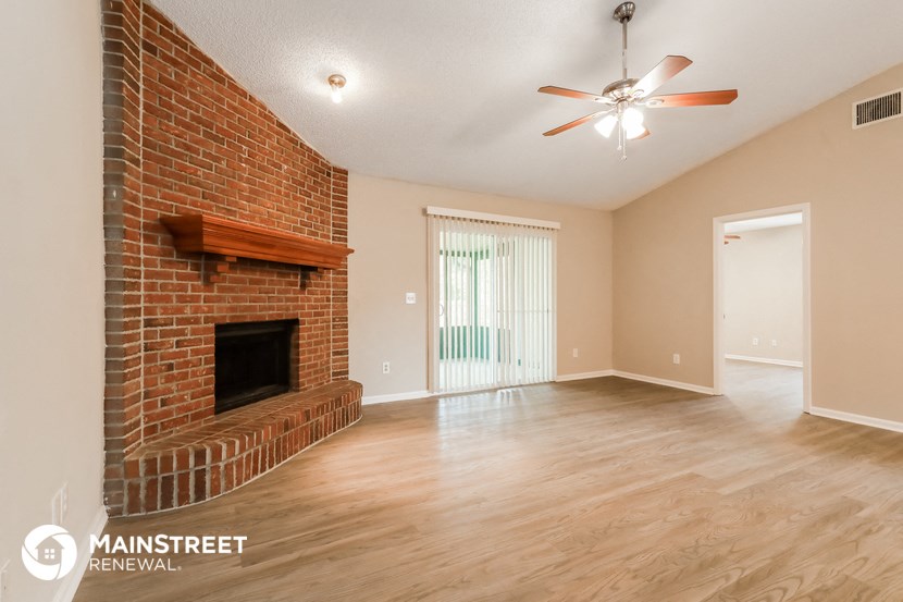 the living room with fireplace and wood flooring and a ceiling fan