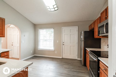 a kitchen with a stove and a refrigerator and a window