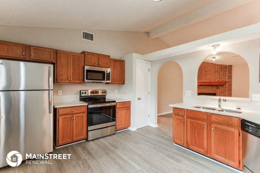 a kitchen with wooden cabinets and stainless steel appliances