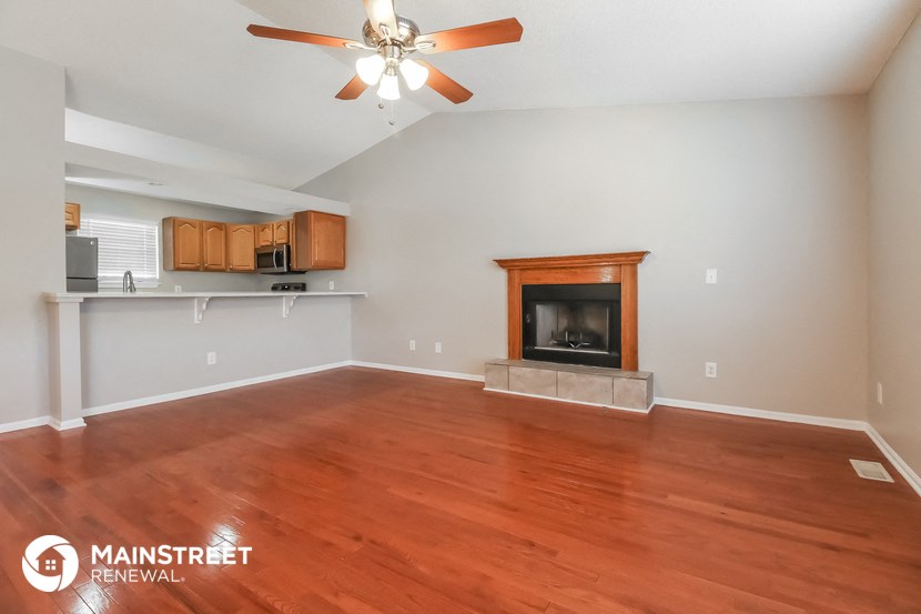 the living room with wood flooring and fireplace
