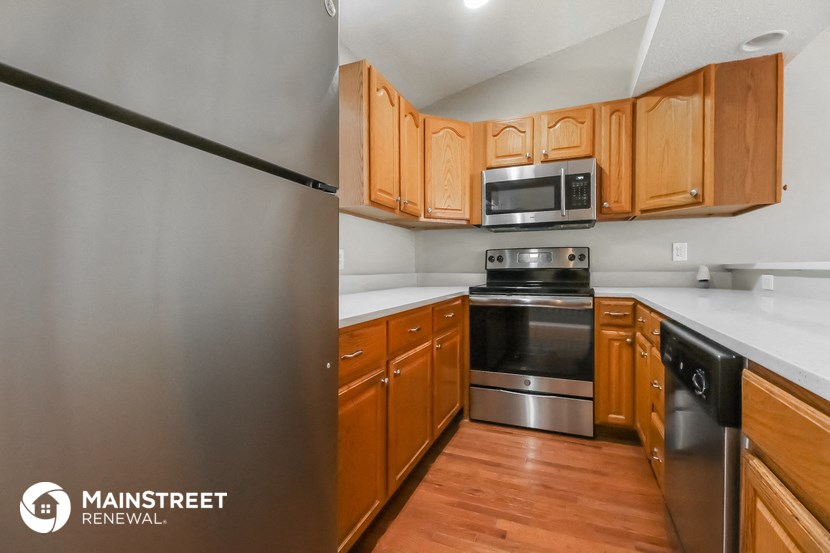 a kitchen with wooden cabinets and stainless steel appliances