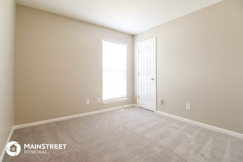 an empty room with a door and a window