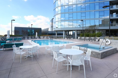 an outdoor patio with tables and chairs next to a pool