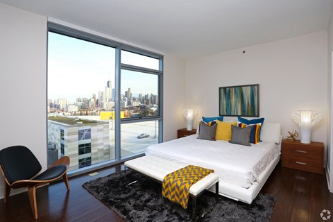 a bedroom with a bed and a view of the city