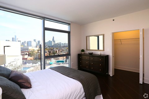 a bedroom with a bed and a view of the city