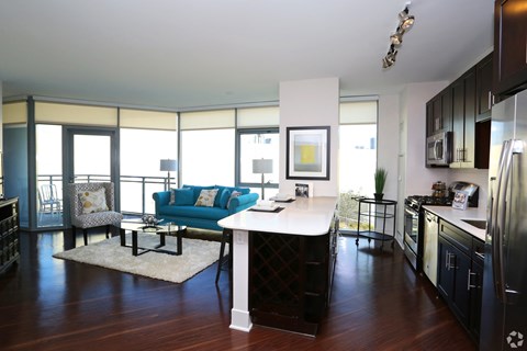 a living room with a kitchen and a blue couch