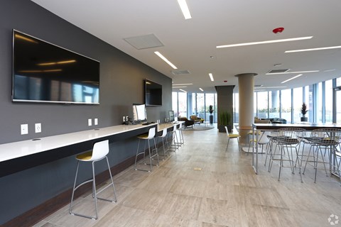 a lounge area with chairs and a counter and a television