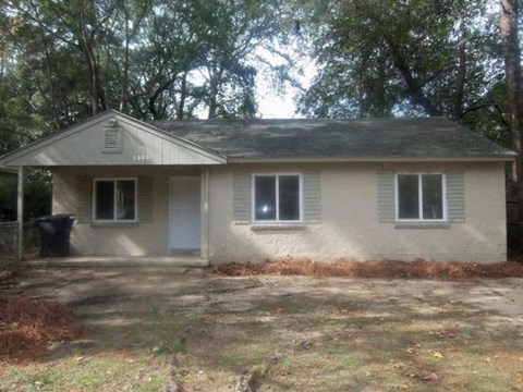 a small house with a yard and some trees