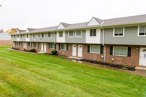 a row of houses with a yard in front of them