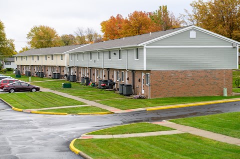 a row of houses with cars parked in front of them