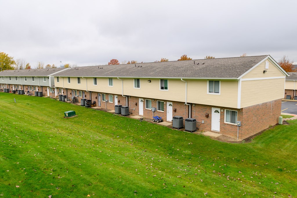 an aerial view of a row of apartment buildings on a green field