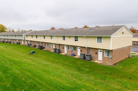 an aerial view of a row of apartment buildings on a green field