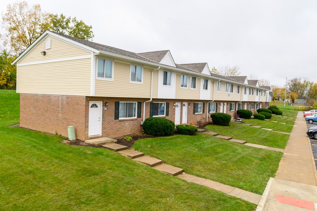 a row of houses on a street with grass and sidewalks