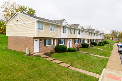 a row of houses on a street with grass and sidewalks
