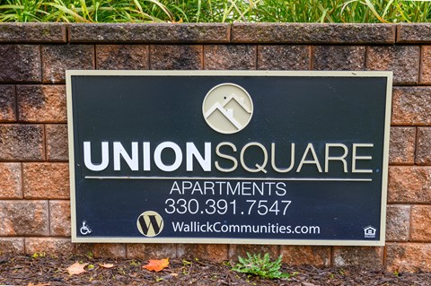 a sign on a brick wall that reads unions square apartments