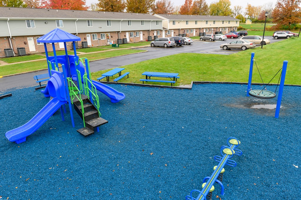 a playground with a swing set and slides in a park