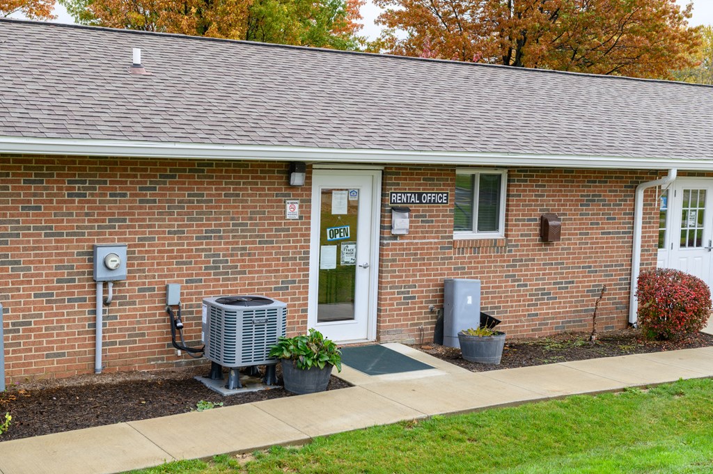 the front of a brick building with a door and a heating unit