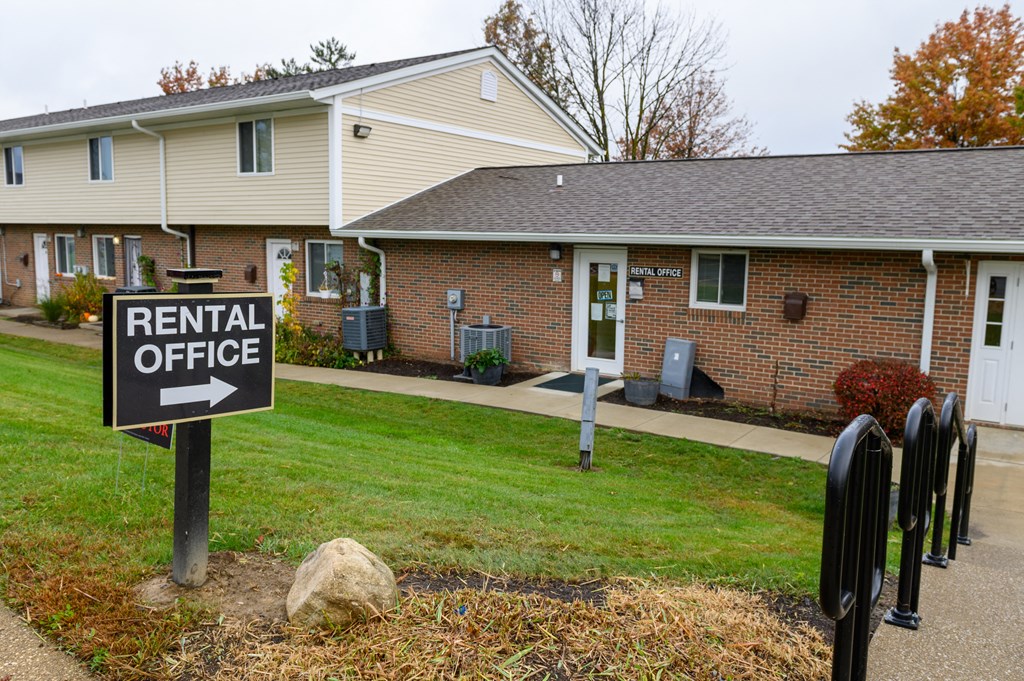 a rental office sign in front of a house