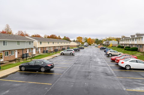 a parking lot filled with cars in front of houses