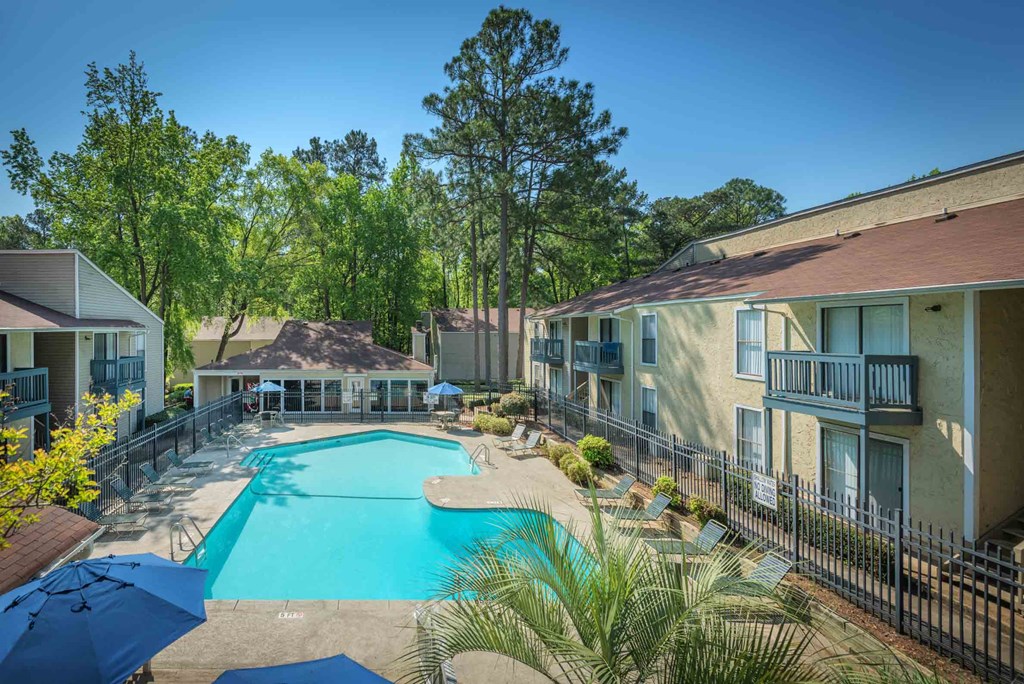 a swimming pool with buildings and trees in the background