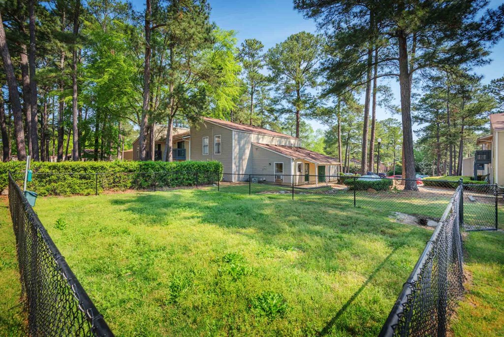 a house with a yard and a fence in front of it