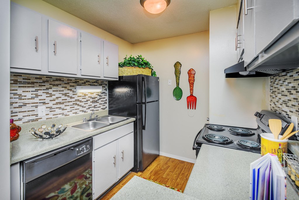 a kitchen with white cabinets and a black refrigerator