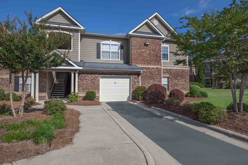 a large brick house with a white garage door in front of it