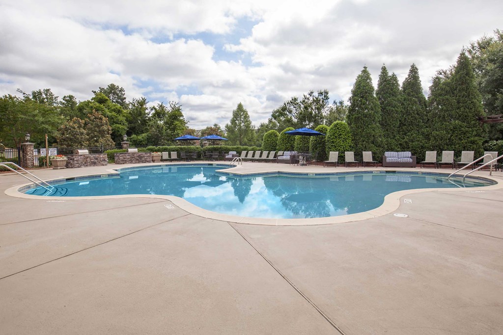 a swimming pool with chairs and umbrellas next to a resort style pool