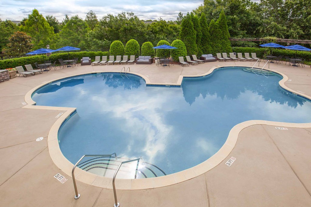 a swimming pool with umbrellas and chairs around it