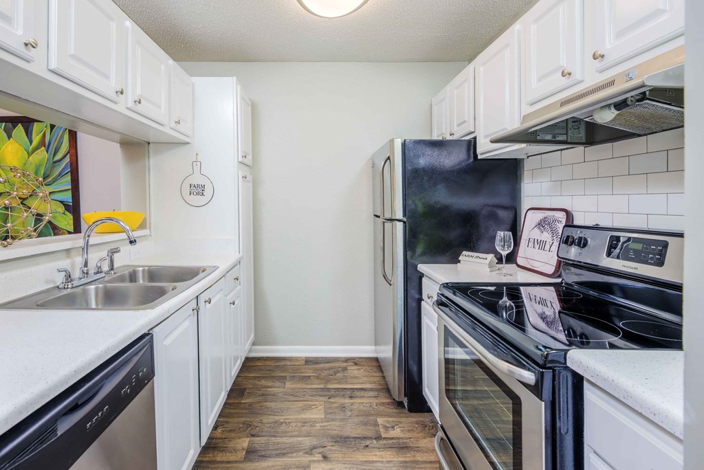 a kitchen with stainless steel appliances and white cabinets