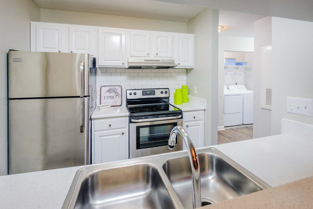 a kitchen with stainless steel appliances and white cabinets