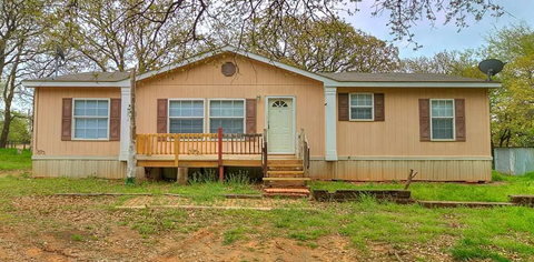 A small house with a porch and a green door.