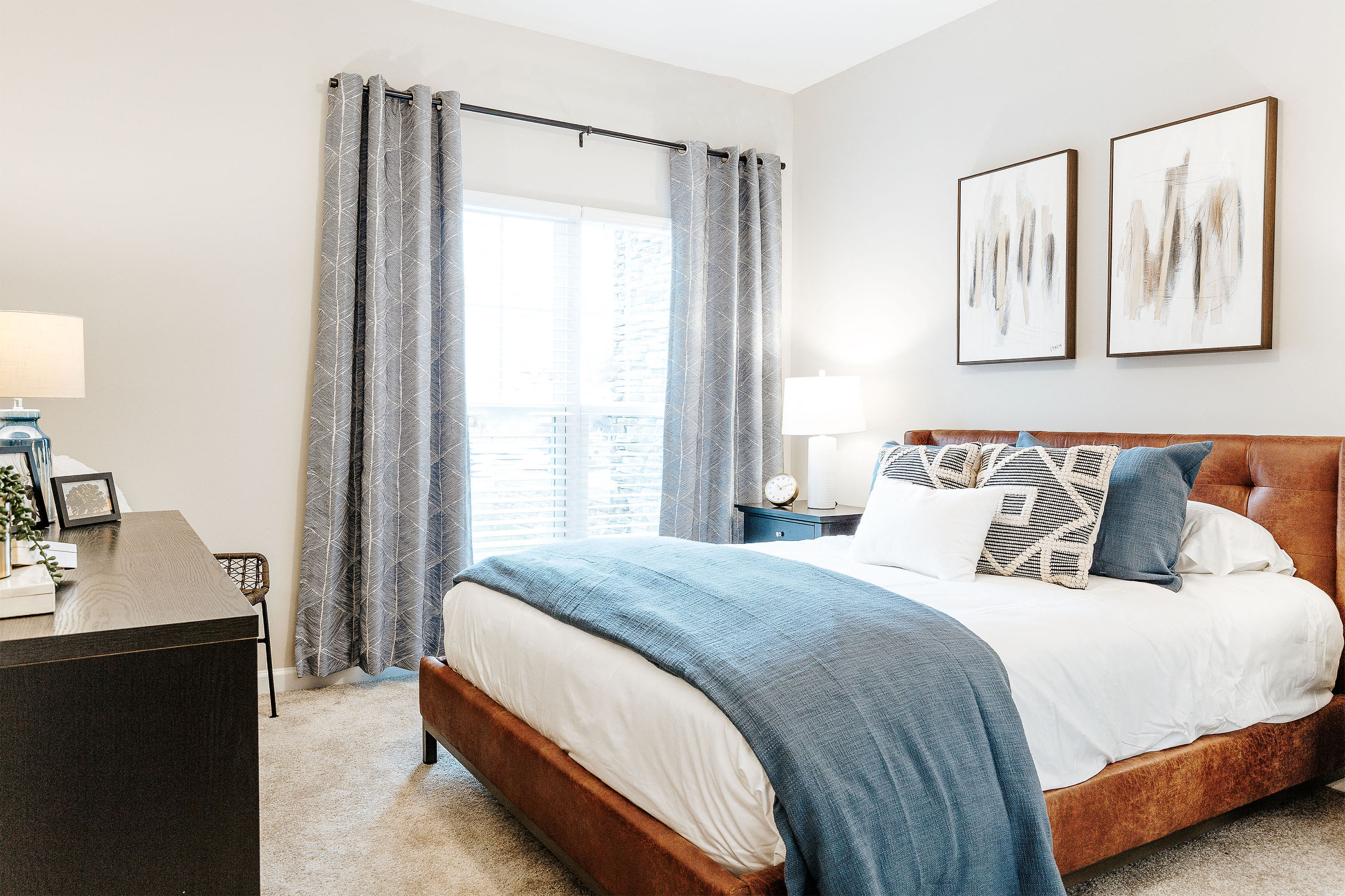 a bedroom with a bed and a window with curtains
