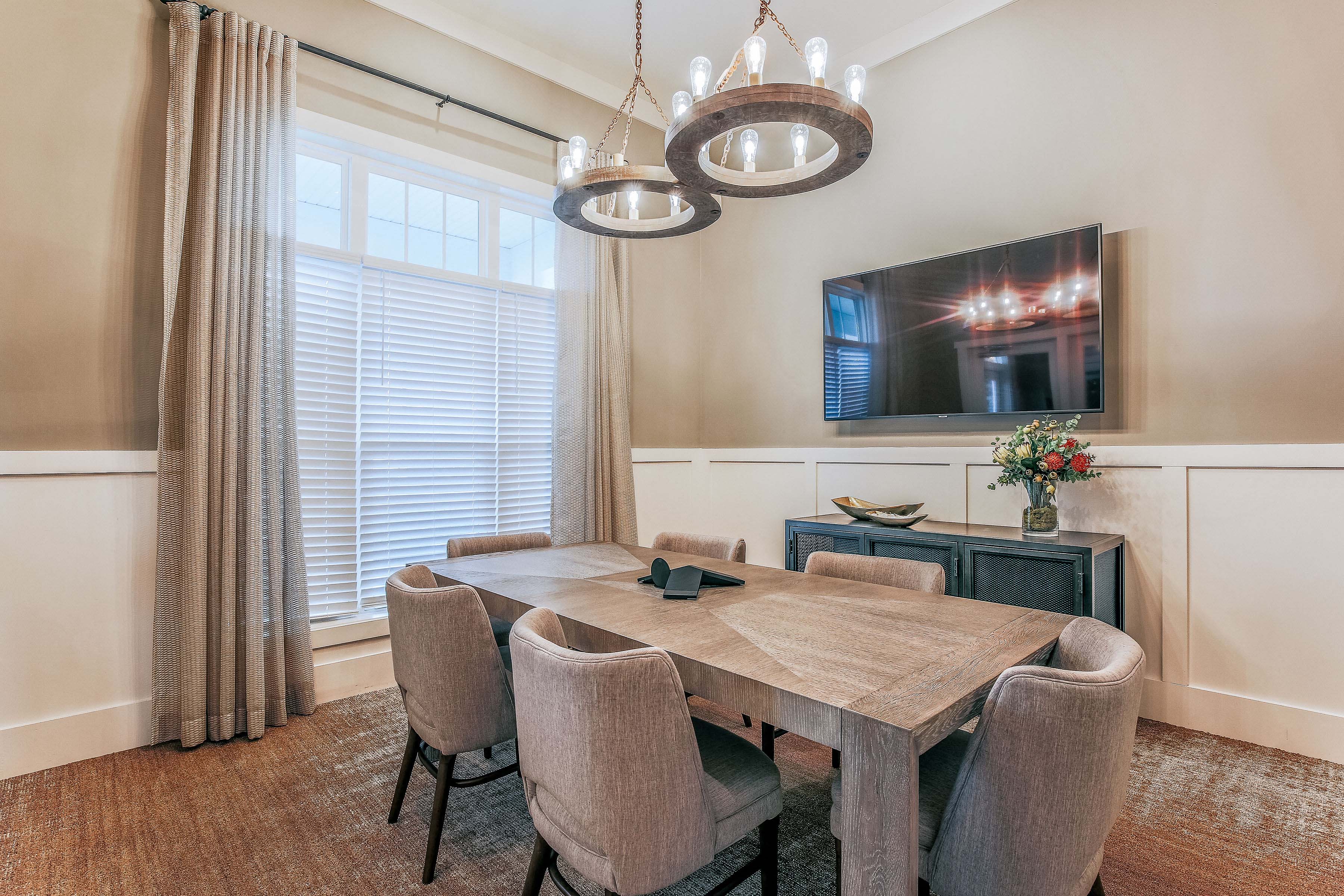 a dining room with a table and chairs and a tv