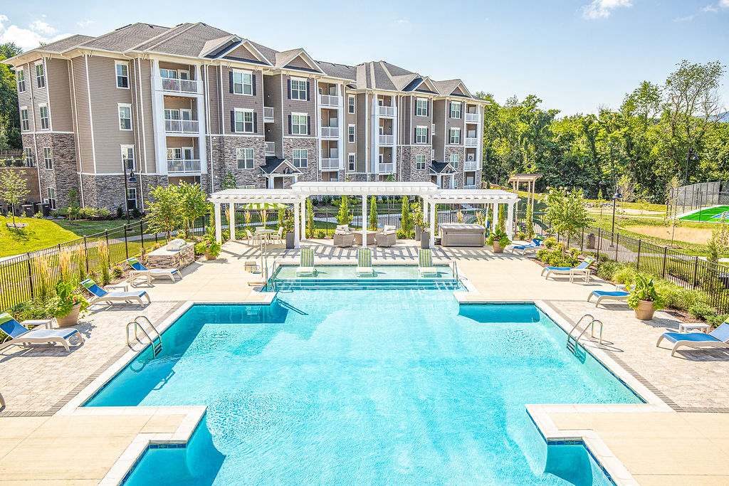 a large swimming pool with a resort style building in the background