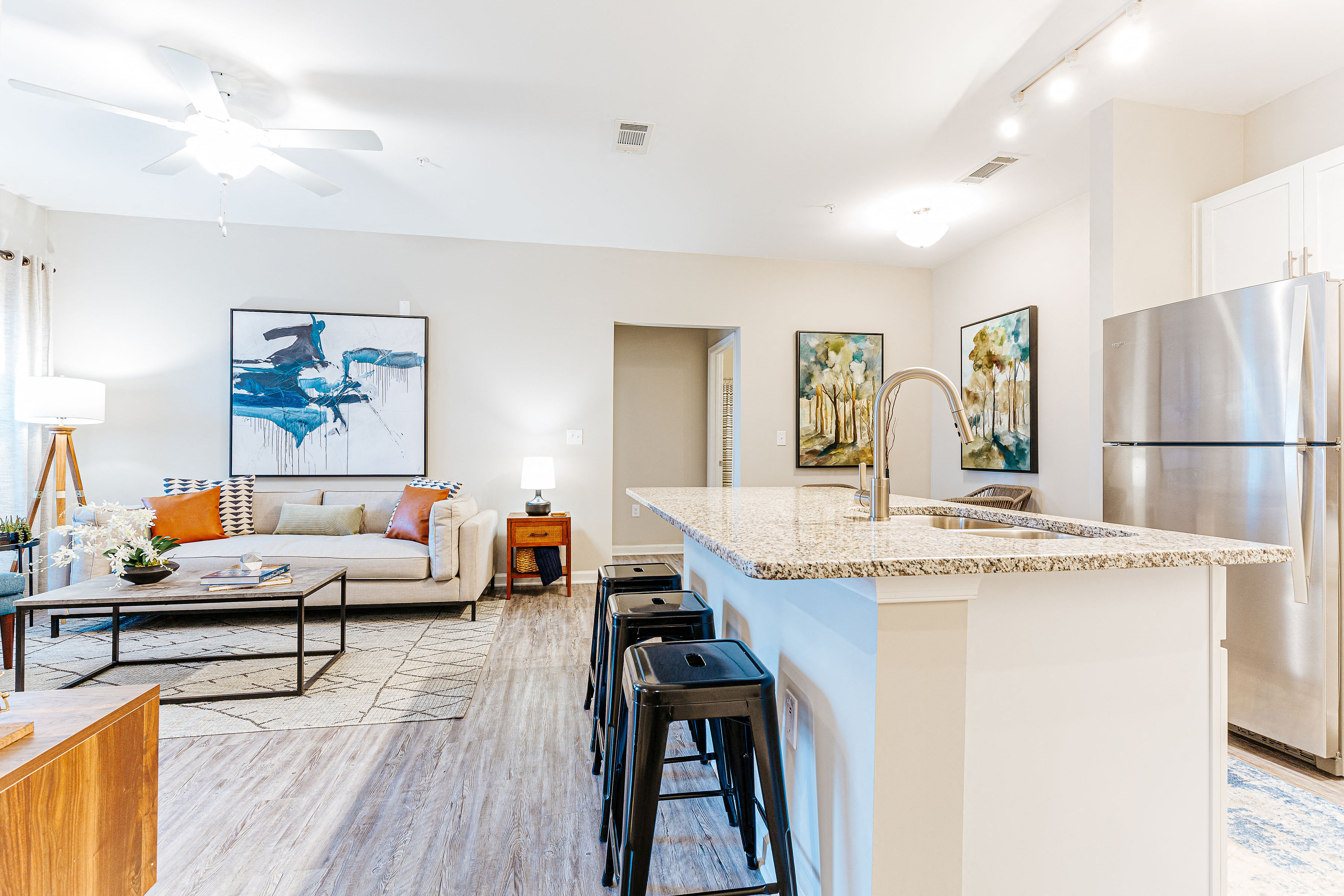 a living room with a kitchen and a refrigerator