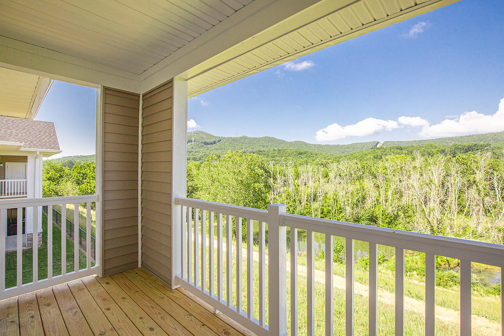 a view of the woods from the balcony of a house