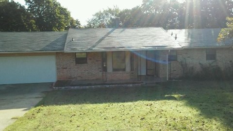 A house with a grey roof and a white garage door.