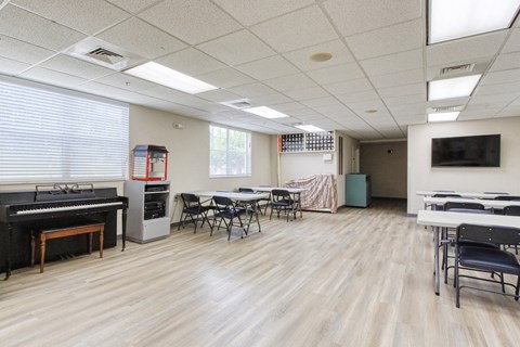 a dining room with tables and chairs and a piano