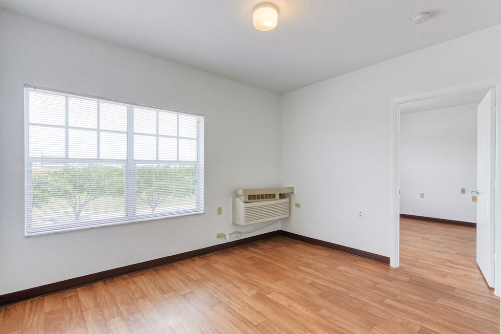 living room with large windows, overhead lighting and AC unit