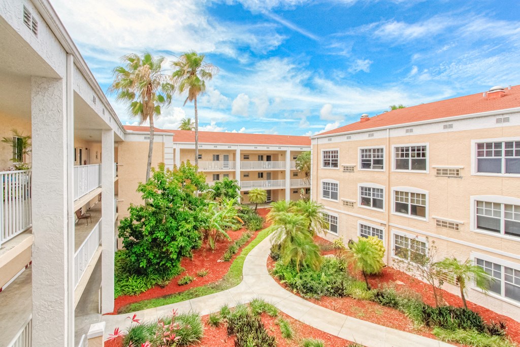 Courtyard between residential buildings with lush landscaping