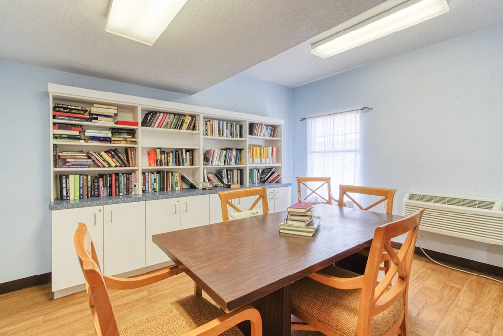 library reading room with many books and large table with chairs