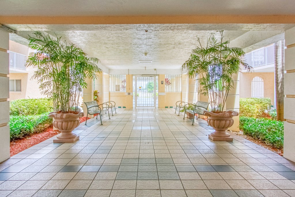 covered walkway with potted plants and benches