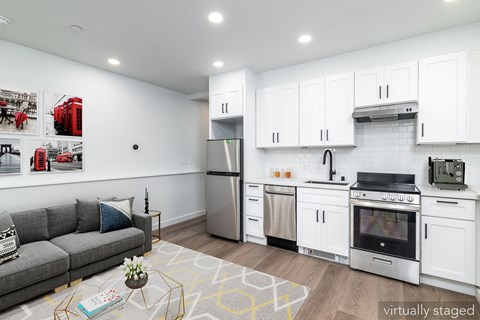 A modern kitchen with a grey sofa and a coffee table.