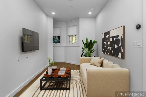 A living room with a couch, a coffee table, and a painting on the wall.