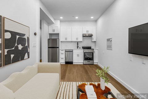 A modern kitchen with white cabinets and stainless steel appliances.