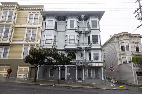 A large, multi-story building with a balcony on the second floor.