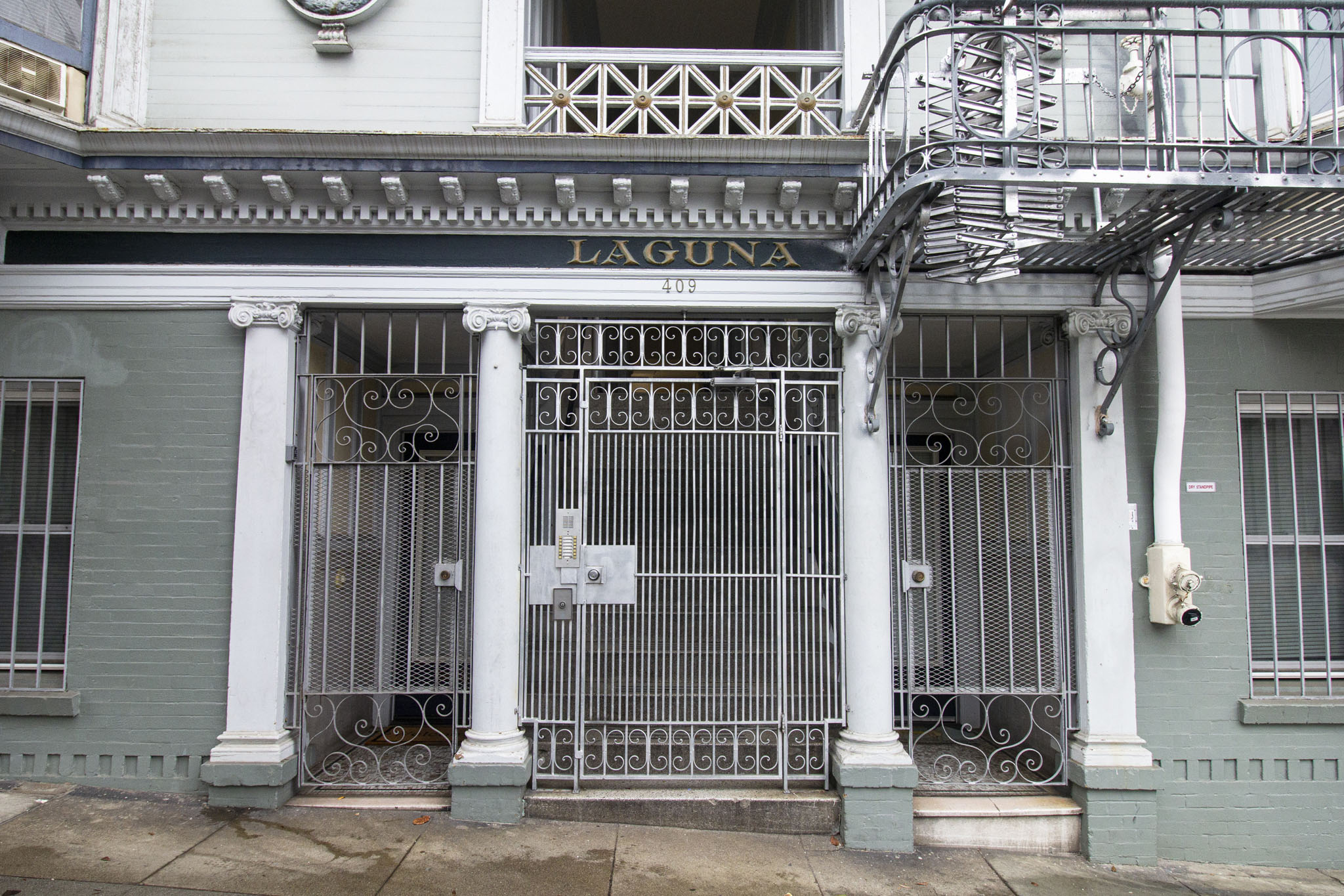 A building with a gate and a sign that says Laguna.