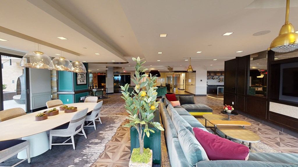 a lounge area with couches tables and chairs and a television