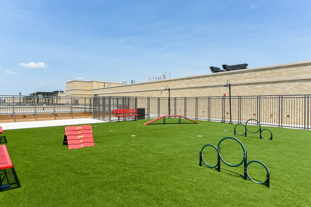 an outdoor play area on the roof of a building with playground equipment